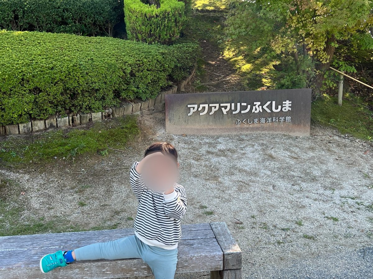 入口の看板の前で